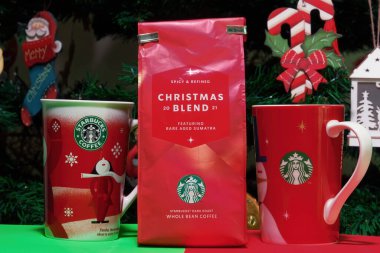 Starbucks Noel kahvesi ve fincanları. Şenlikli arka planda yeşil-beyaz sirk logosu olan tatil bardakları da dahil olmak üzere mevsimlik içecek aralığı.