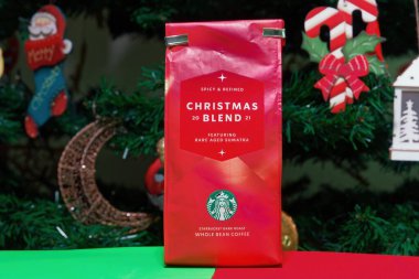 Starbucks Noel karışımı kahve paketi. Yeşil ve beyaz sirk logosuna sahip mevsimlik içecek aralığı, şenlik arka planına karşı.