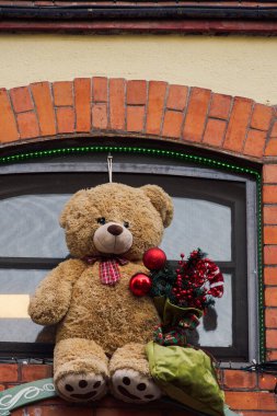 Pencerenin dışında içi doldurulmuş bir oyuncak ayı. Sezonluk oyuncak figürü dışarıda Noel için kullanılıyor..