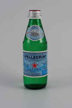 Logolu San Pellegrino doğal maden suyu. İtalyan markası 250 ml cam şişe beyaz arka planda parlayan içerik.