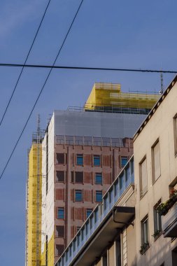 Milan, Italy Torre Velasca skyscraper ground view during renovation.Low angle of 26 floors iconic structure completed at 1958 in architectural tribute to medieval towers.