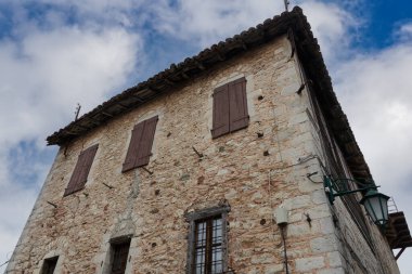 Geleneksel taş, bulutlu mavi gökyüzüne karşı ev inşa etti. Yunanistan 'ın Arcadia Moreloponnese kentindeki tarihi Dimitsana köyündeki eski konutun düşük açılı manzarası.