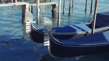 Venedik, İtalya 'nın gündüz vakti demirli gondolları Büyük Kanal' ın sularında kalabalıksız sallanırken ahşap direkler üzerinde demirli..