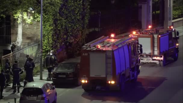 ギリシャ消防団サービスは テッサロニキの夜の都市火災の間に制服を着た消防士とトラックを運行しています ギリシャ — ストック動画