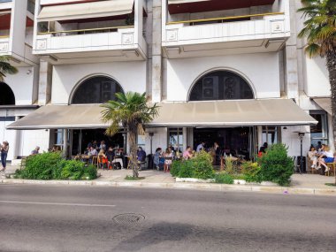 Thessaloniki, Greece - May 14 2021: Evening view of crowd drinking or eating at outdoors seating bar restaurant in Nikis Avenue.