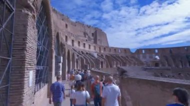 Roma, İtalya - 9 Ekim 2021: Roma Kolezyum Flav amfi tiyatrosu içinde bulutlu mavi gökyüzüne karşı ziyaretçiler.