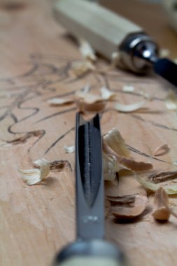 Oyma tahtalar ve talaşlarla yontulmuş keskiler..