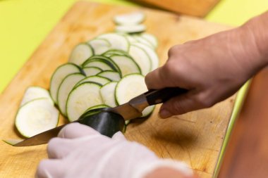 Tahtanın üzerinde bıçakla dilimlenmiş kabak dilimi.