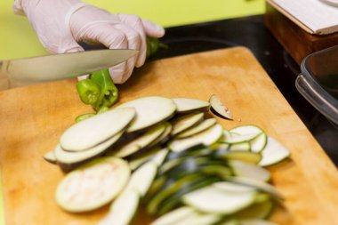 Tahtanın üzerinde bıçakla dilimlenmiş kabak dilimi.