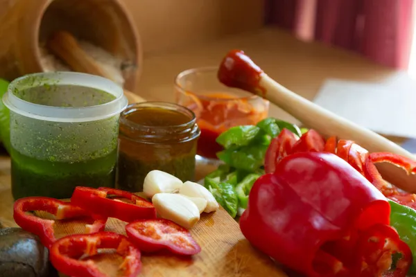 Pimienta roja cortada con cuchillo de cocina y tomate partido sobre tabla de madera — Foto de Stock