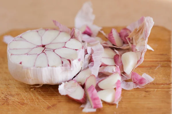 Testa di aglio divisa a metà su tavola di legno in cucina — Foto Stock