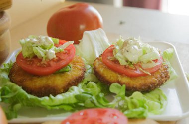 Tahtada salata ve domatesli hamburger hazırlığı