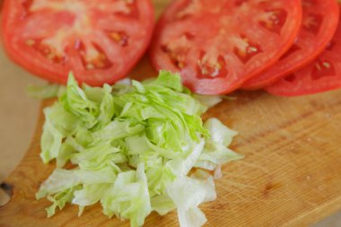 Tahtada salata ve domatesli hamburger hazırlığı