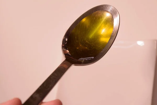 Spoon with sunflower oil on white table — Stock Photo, Image