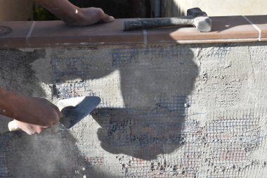 Duvarcılıkta çalışan bir adamın elleri, tanınmaz halde.