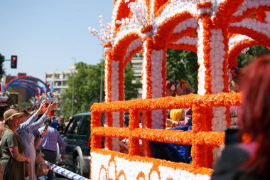 CORDOBA,SPAIN - 2 May. 2022: Battle of the flowers, Women dressed in traditional flamenco dress on cart throwing flowers to the public in the Battle of Flowers parade, which marks the start of Cordoba