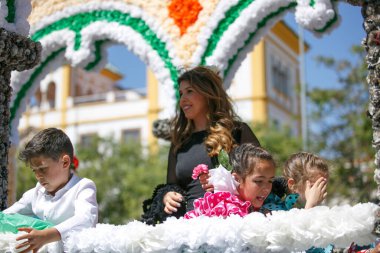 Cordoba, İspanya - 2 Mayıs. 2022: Çiçek Savaşı: Geleneksel flamenko elbiseli kadınlar, Cordoba 'nın başlangıcı olan Çiçekler Savaşı' nda halka çiçek atıyor.