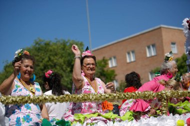 Cordoba, İspanya - 2 Mayıs. 2022: Çiçek Savaşı: Geleneksel flamenko elbiseli kadınlar, Cordoba 'nın başlangıcı olan Çiçekler Savaşı' nda halka çiçek atıyor.