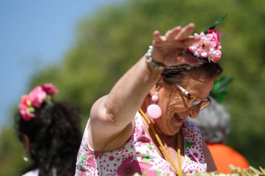 Cordoba, İspanya - 2 Mayıs. 2022: Çiçek Savaşı: Geleneksel flamenko elbiseli kadınlar, Cordoba 'nın başlangıcı olan Çiçekler Savaşı' nda halka çiçek atıyor.