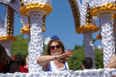 Cordoba, İspanya - 2 Mayıs. 2022: Çiçek Savaşı: Geleneksel flamenko elbiseli kadınlar, Cordoba 'nın başlangıcı olan Çiçekler Savaşı' nda halka çiçek atıyor.