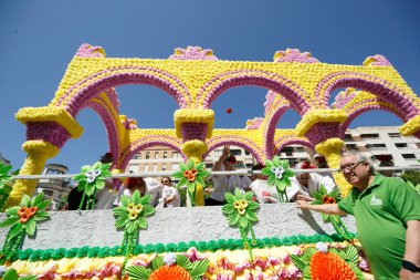 CORDOBA,SPAIN - 2 May. 2022: Battle of the flowers, Women dressed in traditional flamenco dress on cart throwing flowers to the public in the Battle of Flowers parade, which marks the start of Cordoba