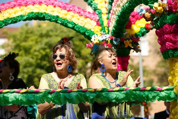 CORDOBA, SPANJE - 2 mei. 2022: Slag om de bloemen, Vrouwen gekleed in traditionele flamenco jurk op kar gooien bloemen voor het publiek in de Battle of Flowers parade, die het begin van Cordoba markeert — Stockfoto