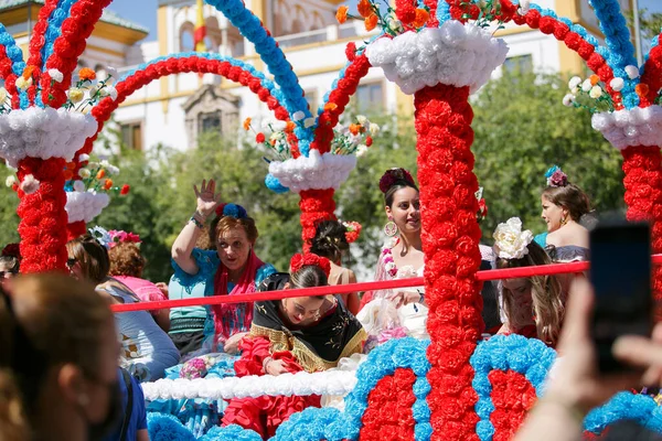 CORDOBA,SPAIN - 2 May. 2022: Battle of the flowers, Women dressed in traditional flamenco dress on cart throwing flowers to the public in the Battle of Flowers parade, which marks the start of Cordoba — Stockfoto