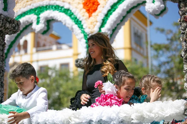 Cordoba, İspanya - 2 Mayıs. 2022: Çiçek Savaşı: Geleneksel flamenko elbiseli kadınlar, Cordoba 'nın başlangıcı olan Çiçekler Savaşı' nda halka çiçek atıyor.