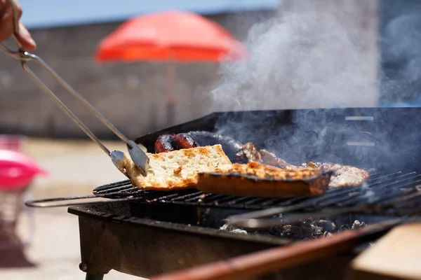 Pão Torrado Mão Com Pinças Churrasco Caseiro Fora Dia Ensolarado — Fotografia de Stock