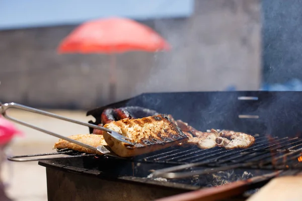 Pão Torrado Mão Com Pinças Churrasco Caseiro Fora Dia Ensolarado — Fotografia de Stock