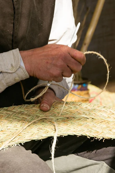 Esparto çimlerinde iğne ile çalışan bir zanaatkar, sokakta zanaat, geleneksel zanaat.