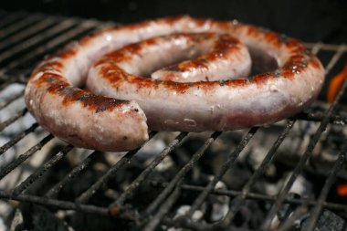 Barbeküde taze sosis pişiyor, evin açık havasında..
