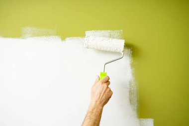 Erkek dekoratör duvarları patenle boyuyor, resim yapıyor..