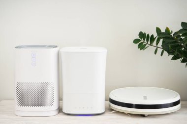 Modern robot elektrik süpürgesi, nemlendirici ve hava temizleyicisi renk arkaplanı, metin için boşluk.