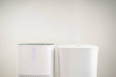 Gri arka planda modern nemlendirici ve hava temizleyici, yakın plan. Metin için boşluk.