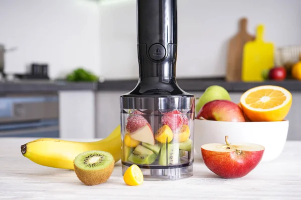 Organik çiğ meyveleri karıştırmak için el blendırı. Vitamin diyeti yapmak için. Sağlıklı yiyecekler. Yakın çekim..