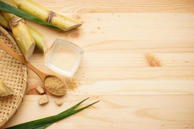 Şeker kamışı, taze baston suyu ve esmer şeker ahşap bir zemin üzerinde metin için yer var. Üst görünüm.