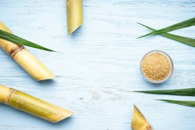 Tahta zemin üzerinde şeker kamışı ve esmer şeker ve metin için yer var. Üst görünüm.