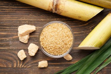 Tahta arka planda şeker kamışı ve esmer şeker..