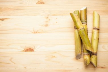 Tahta arka planda şeker kamışı ve mesaj için yer var. Düz yatıyordu.