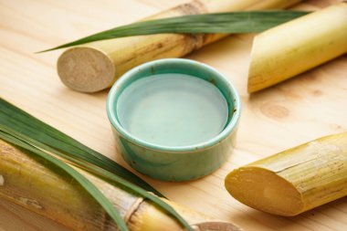 Yakın plan şeker kamışı ve tahta arka planda taze baston suyu..