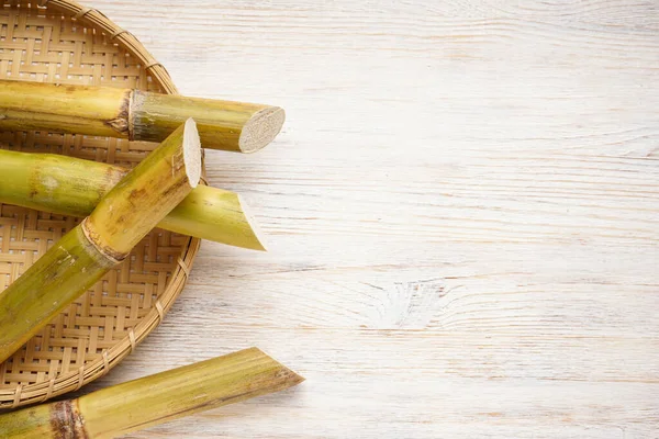 Tahta bir arka planda, kamış tepside şeker kamışı ve metin için yer var. Düz yatıyordu.