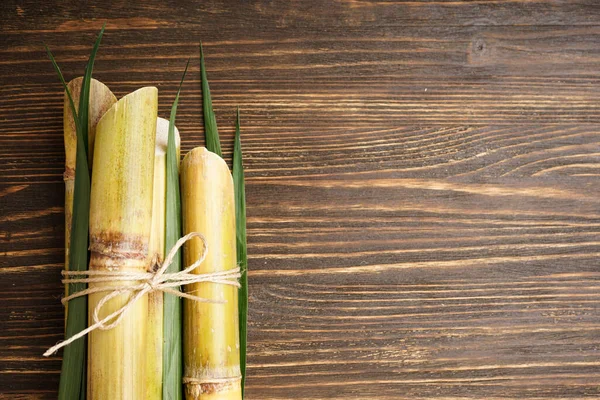 Tahta arka planda şeker kamışına yakın plan, metin için yer var. Üst görünüm.