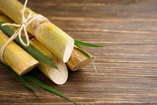 Tahta arka plandaki şeker kamışını kapat ve metin için yer aç. Üst görünüm.