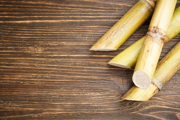 Ahşap zemin üzerine yakın plan şeker kamışı ve metin için yer. Üst görünüm