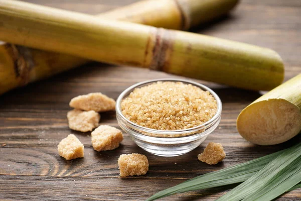 Tahta arka planda şeker kamışı ve esmer şeker. Yakın plan..