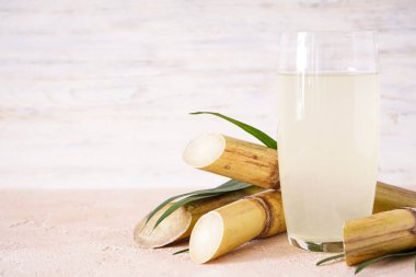 Tahta arka planda şeker kamışı ve taze baston suyu, metin için boşluk..