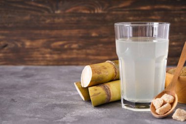 Taze baston suyu ve arkaplanda kahverengi şeker, metin için boşluk.