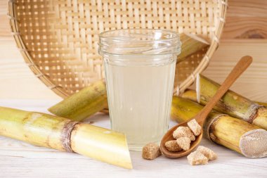 Taze baston suyu ve açık arkaplanda granüllü esmer şeker..