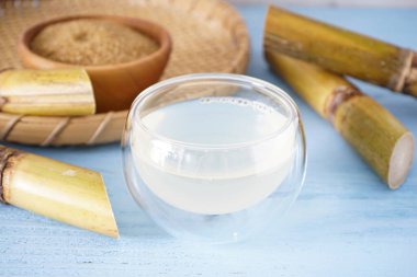 Tahta arka planda taze baston suyu ve şeker kamışı..